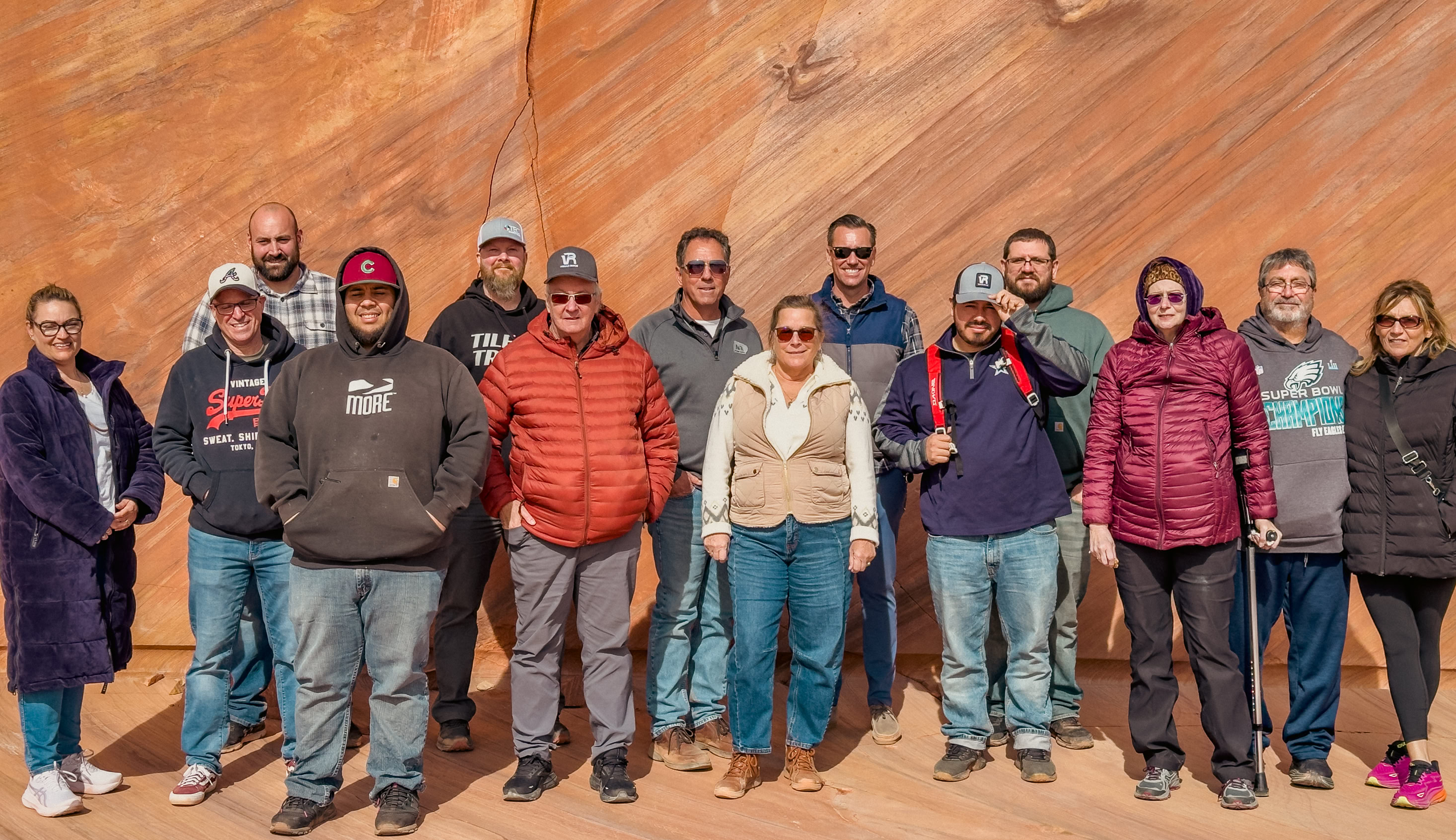 Teachers Workshop Tour people standing around in a factory with hardhats on as one man stands on the podium pointing out different equipment.