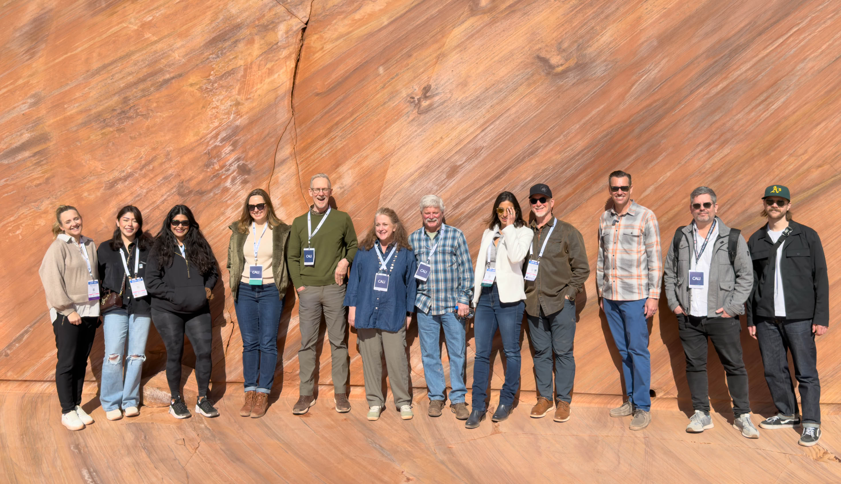 Teachers Workshop Tour people standing around in a factory with hardhats on as one man stands on the podium pointing out different equipment.