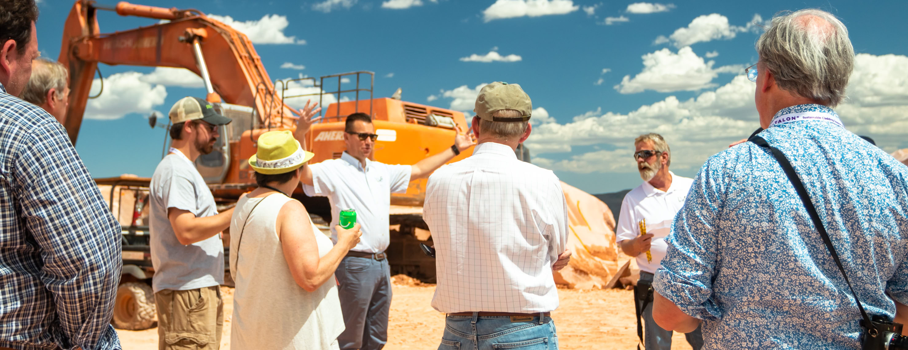 AIA TOUR AT LAS VEGAS ROCK man standing in front of heavy equipment explaining something to other people standing around